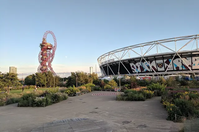 Planted gardens in Queen Elizabeth Olympic Park with the Orbit tower and London Stadium